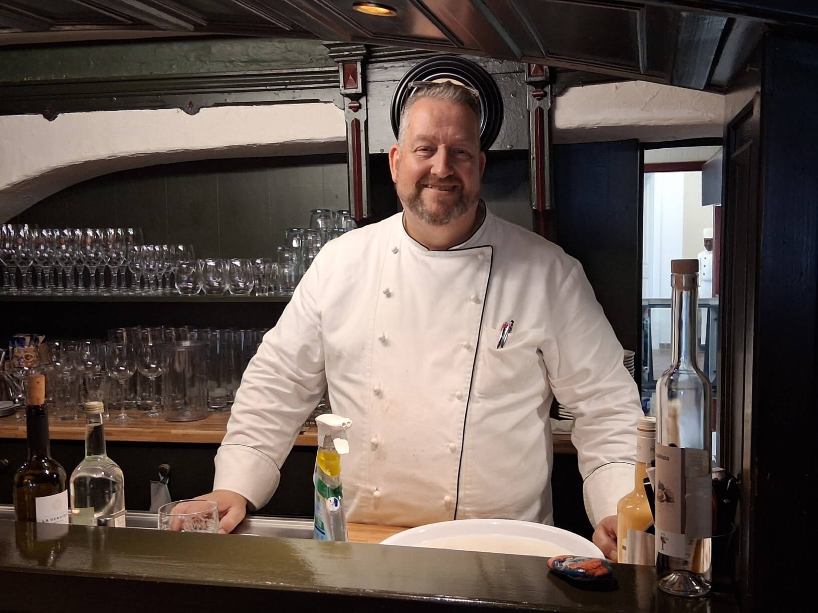 Der Koch Jörg Gattorf steht in seinem Restaurant und lächelt in die Kamera
